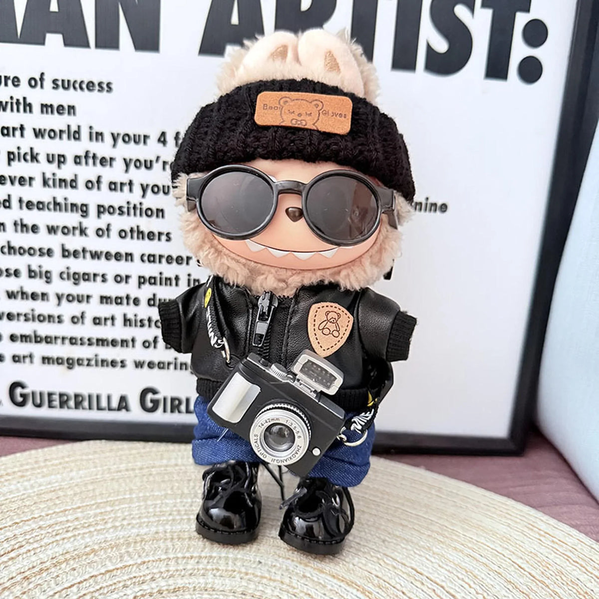 Bear Brand Black Leather Jacket + Deep-Cuffed Jeans + Black Flipped-Brim Hat + Lace-Up Black Dress Shoes + Black Camera + Black Sunglasses